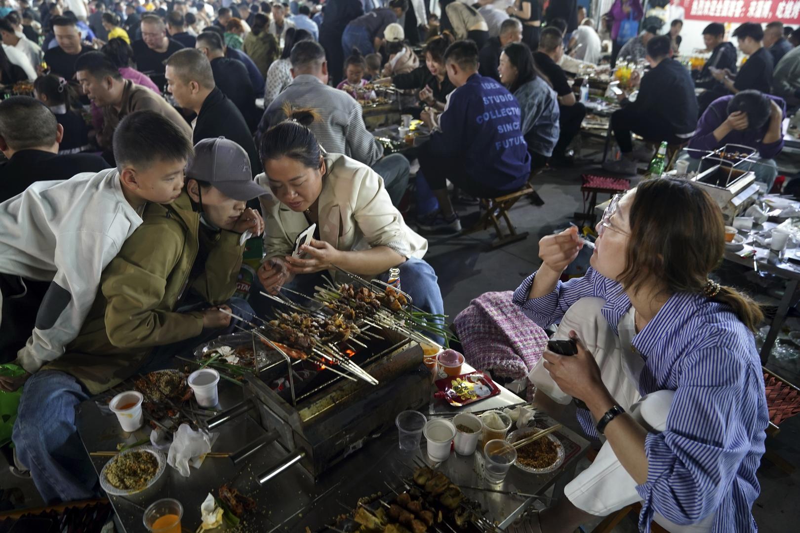 山东淄博，游客们一起品味美食。图据视觉中国
