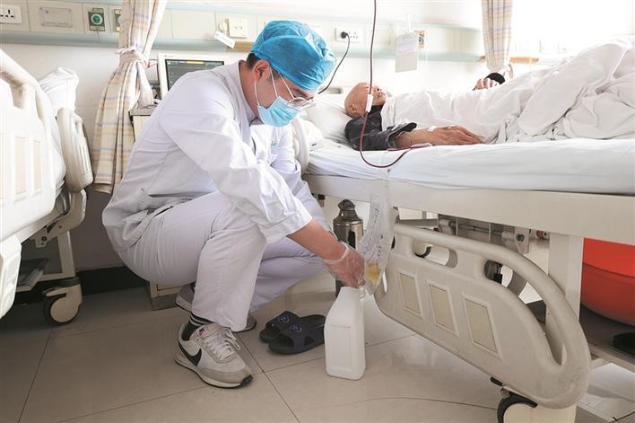 5月5日,八师石河子市人民医院肾病内科男护士曹宁为患者清理导尿袋里