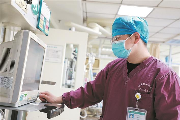 4月25日晚上,一师医院重症医学科护士王邦茂在看患者的心电图.胡珺 摄