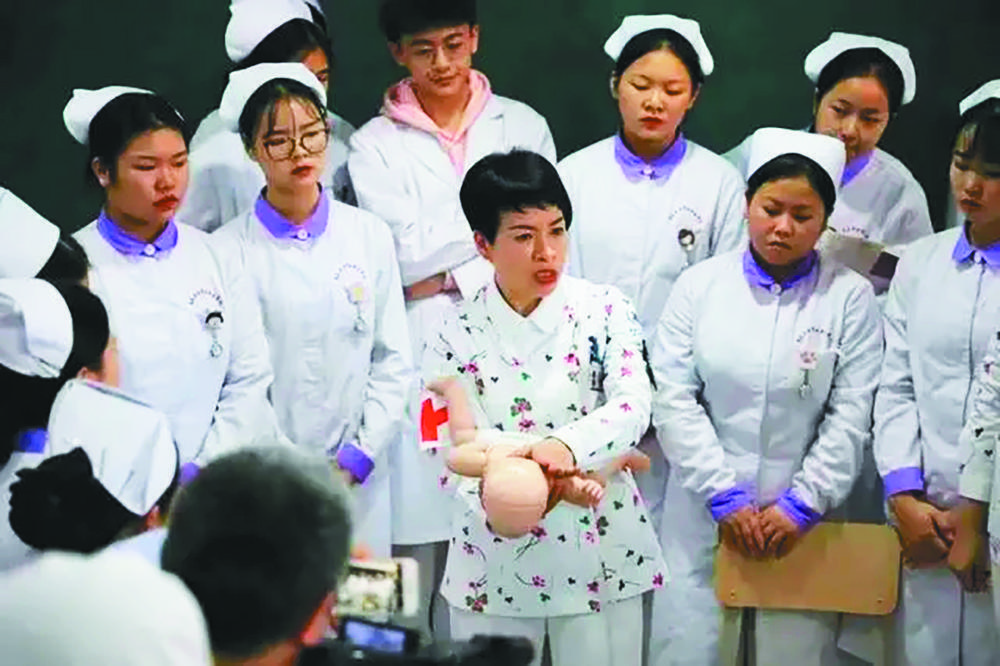 甘秀妮在教年轻护士护理技巧