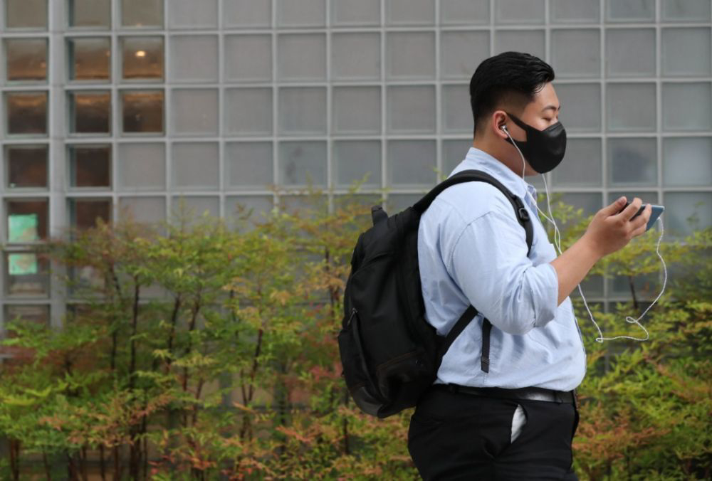 2021年7月9日,戴口罩的行人走在韩国首尔清溪川附近的街道上.