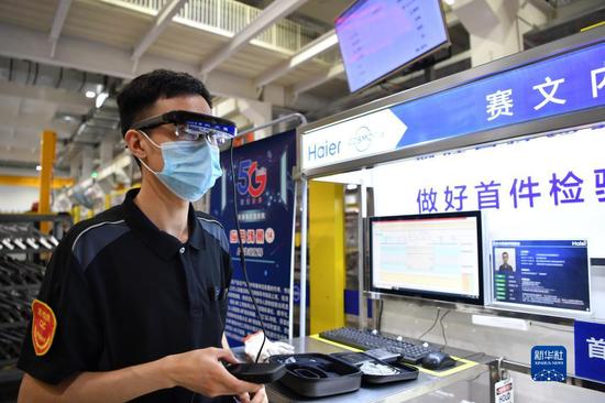 在天津海尔洗衣机互联工厂内，工作人员利用5G技术进行检验工作（ 2020年6月22日摄）。新华社记者李然摄