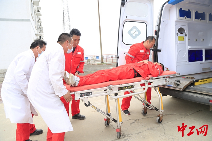 演练中,医护人员等将食物中毒患者推上救护车.陈琪 摄