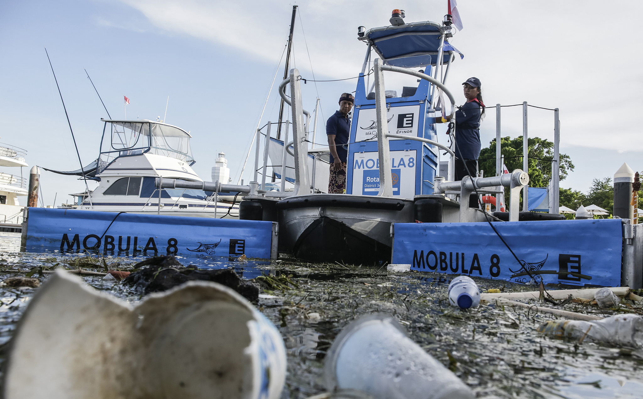工人们在贝诺阿港操作mobula 8海洋清洁船,处理海洋垃圾