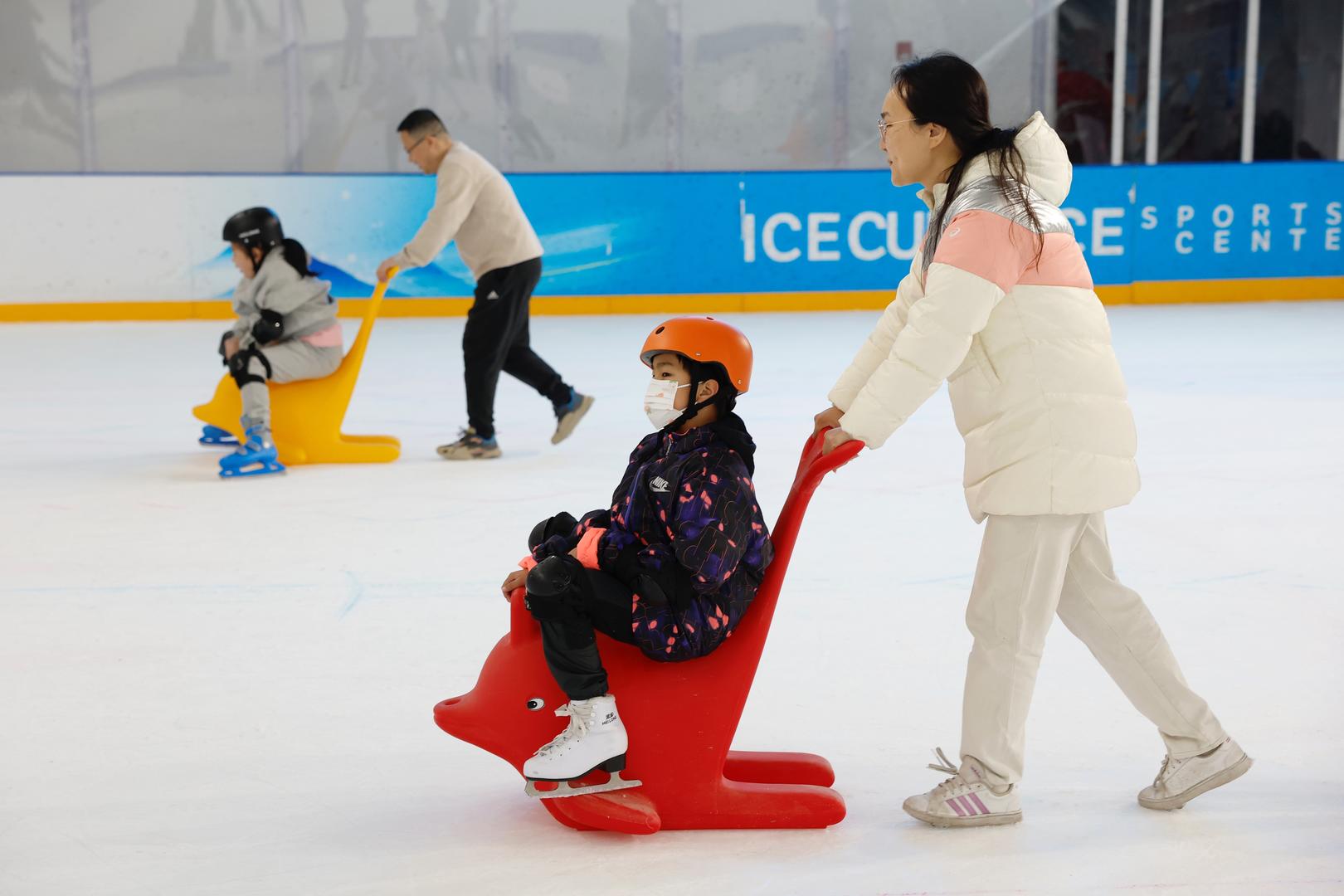 ↑“星星的孩子”在家人陪伴下进行冰上亲子体验（中新社记者 韩海丹 摄） 据视觉中国  