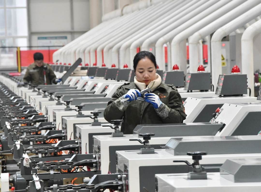 德五金制造有限公司,工人正在数字化智能生产车间检查设备运行情况