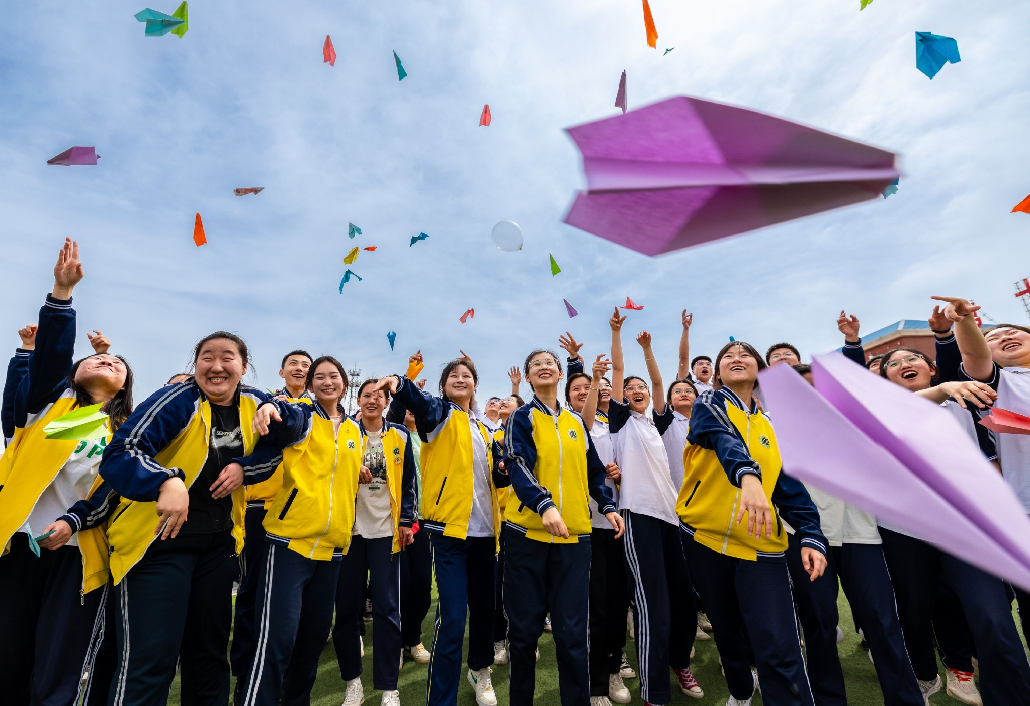 高三年级学生将写有自己梦想的纸飞机抛向空中.通讯员 丁根厚 摄
