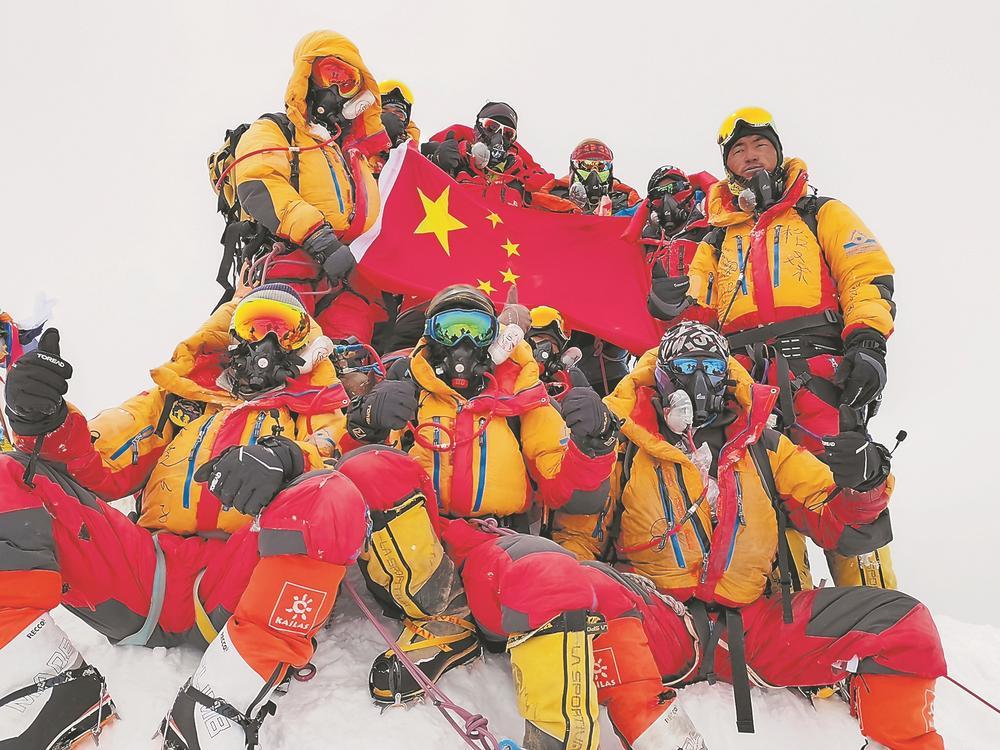 23日,科考登顶队员在珠峰峰顶展示国旗.