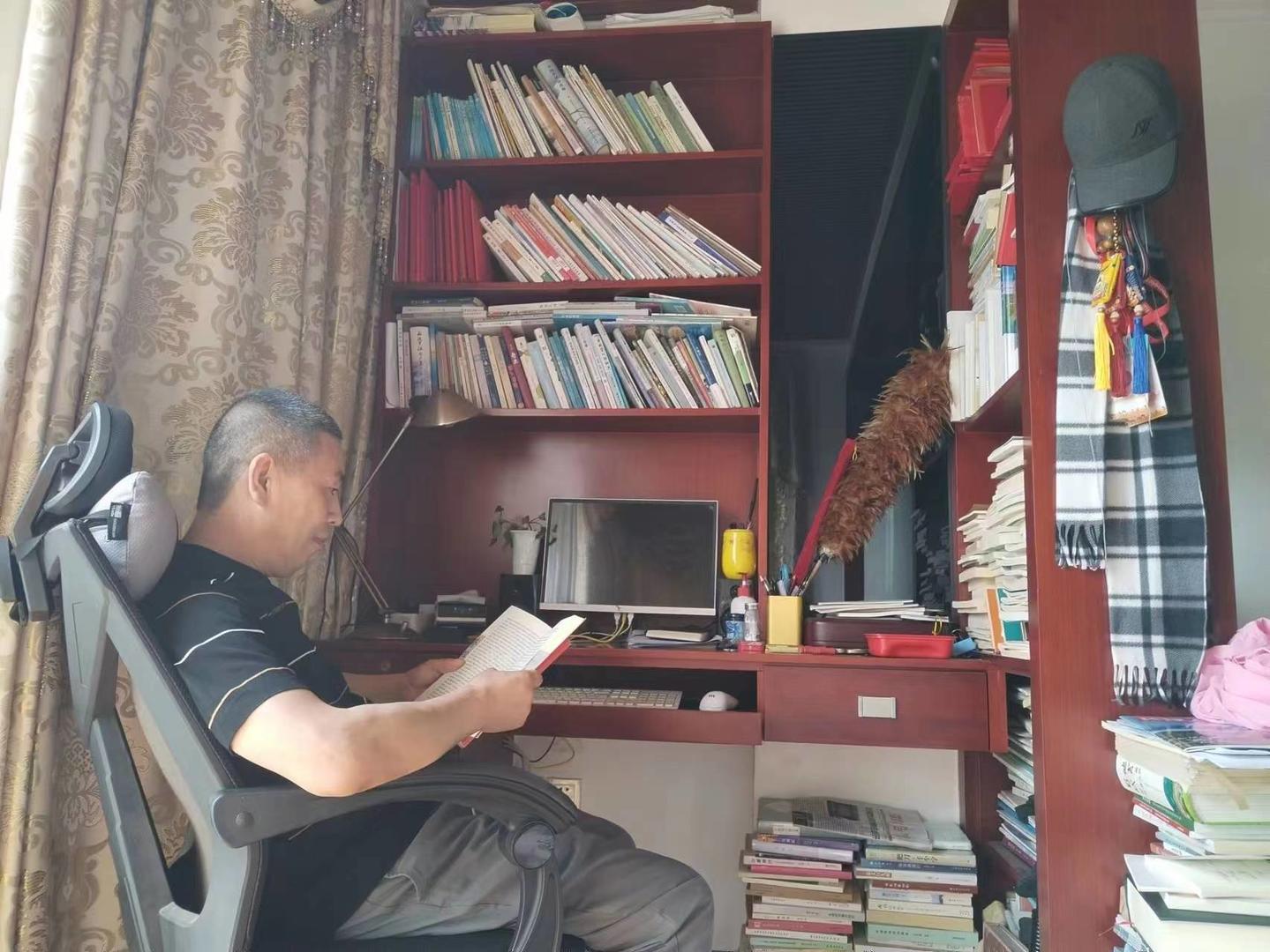 ↑闲暇时，杨俊富喜欢在阳台上阅读
