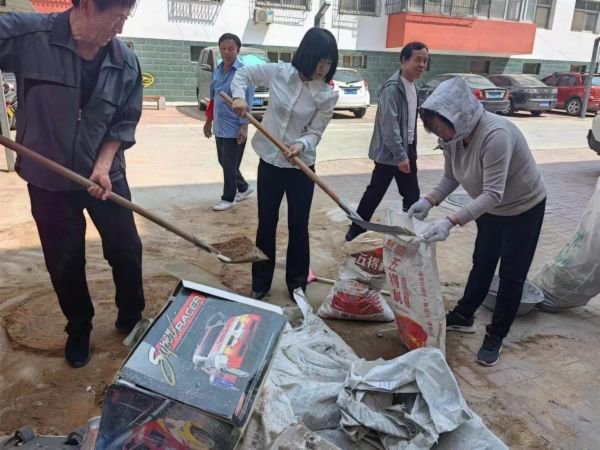 5月24日，都阳路街道金源B区社区工作人员和居民一起修理破损的污水井井盖。全媒体中心 通讯员 孟文静  记者 李正男 摄