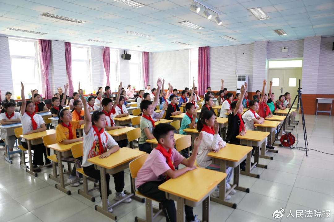 图为学生们积极举手,踊跃发言.