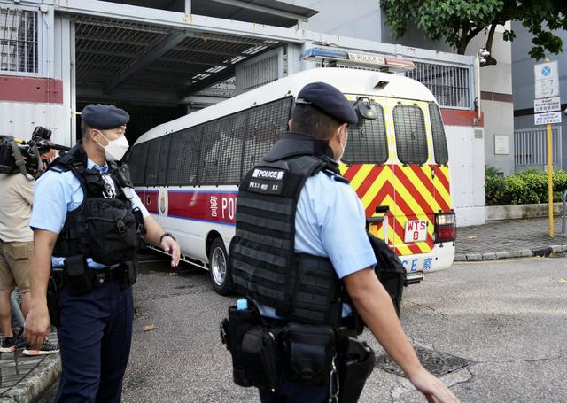 香港商场谋杀案嫌犯上午被警车押解抵达法庭，有执法人员在法庭外戒备。图自香港星岛网