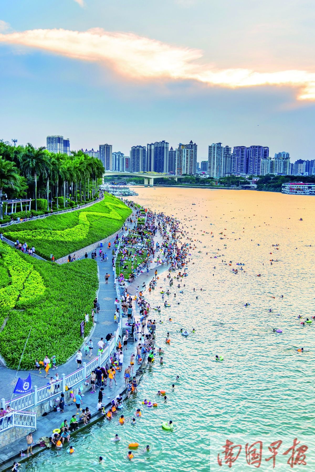 昨晚7时,邕江江滨休闲公园一带,市民在晚霞下游泳.记者 邹财麟 摄