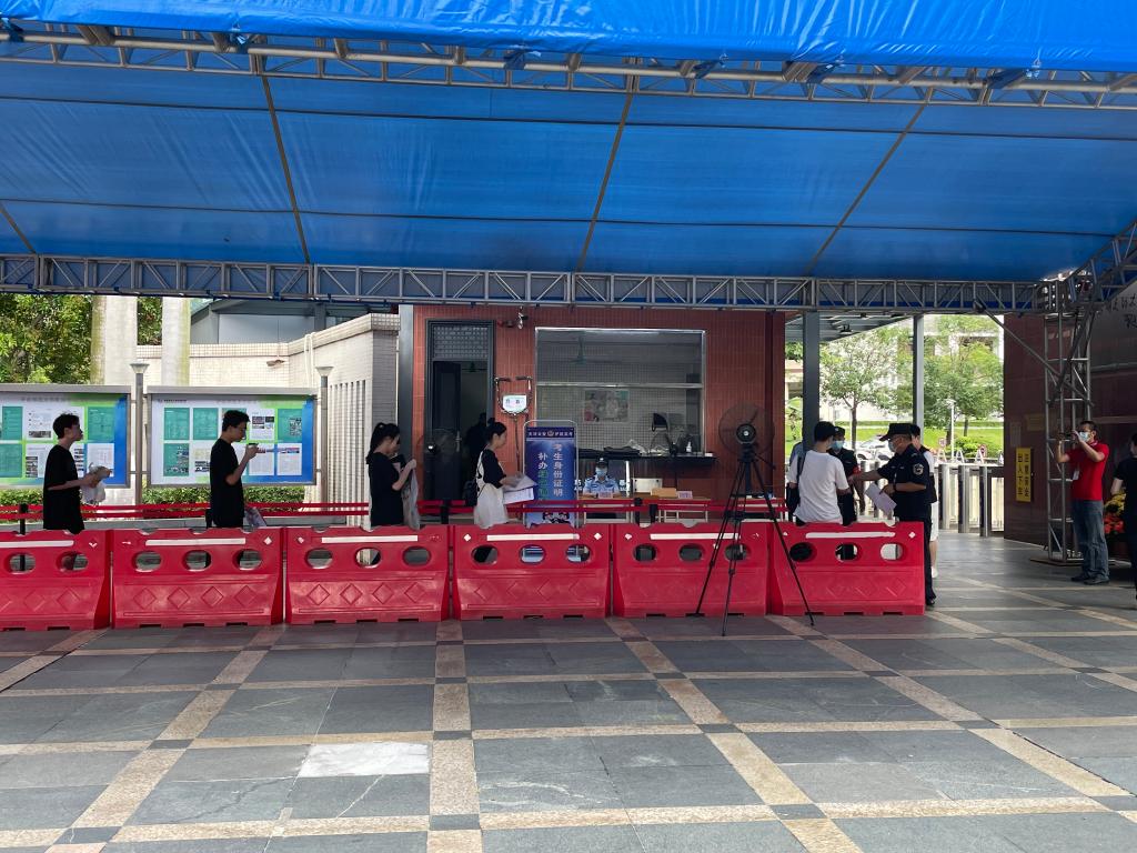 6月7日,在华南师范大学附属中学考点门口,考生正在有序进入考场.