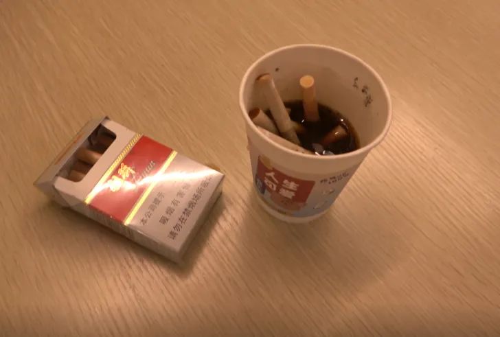 酒吧负责人办公室内用纸杯做的烟灰缸,里面塞满了烟头.(彭成城 摄)