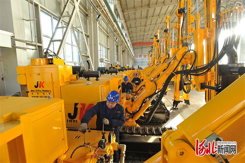 图为张家口市宣化金科钻孔机械公司员工在钻机装配生产线上工作.