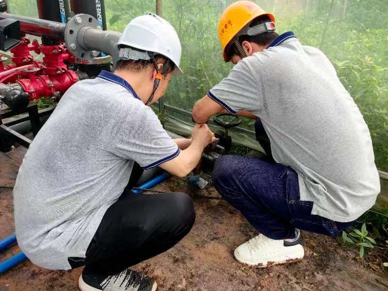 志愿者们正为基地灌溉调试设备。受访者供图