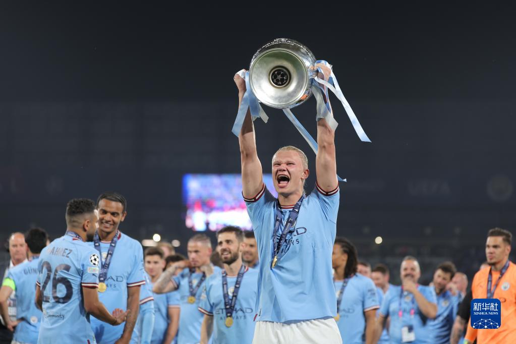 6月10日,曼彻斯特城队球员哈兰德捧杯庆祝.新华社发