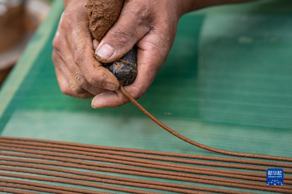 在西藏尼木县吞巴镇吞达村,次仁多吉在制作藏香(6月9日摄).