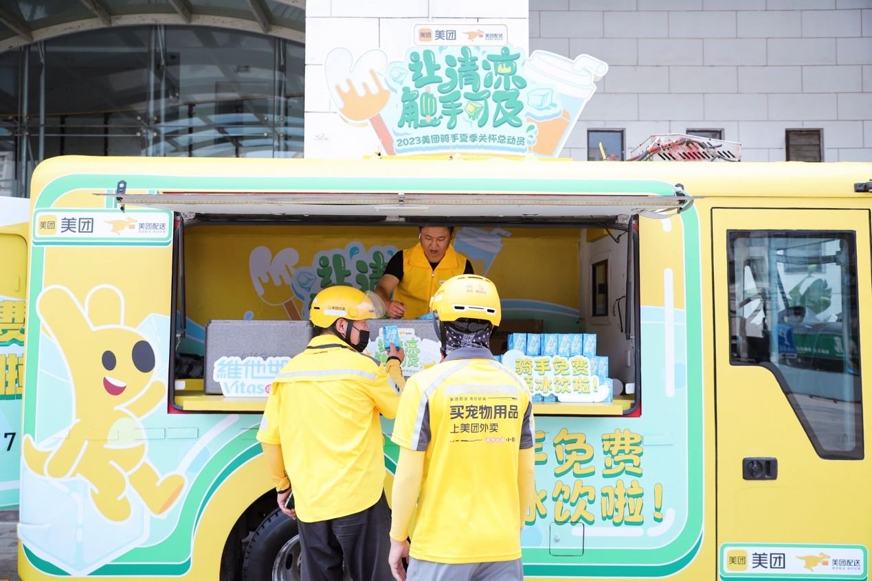 图为外卖骑手在美团巡回冷饮车领取免费饮料.黄强摄 &nbsp