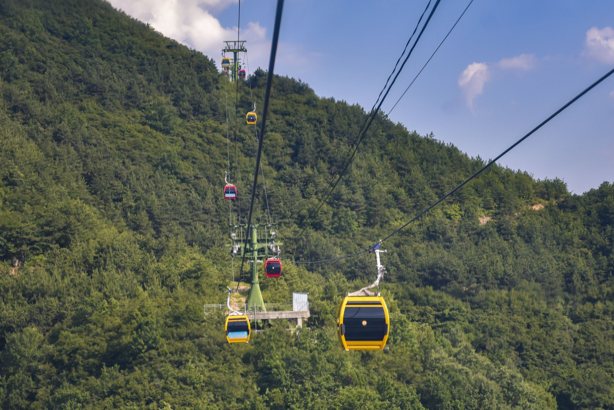 采访团乘坐空中索道翻越大山