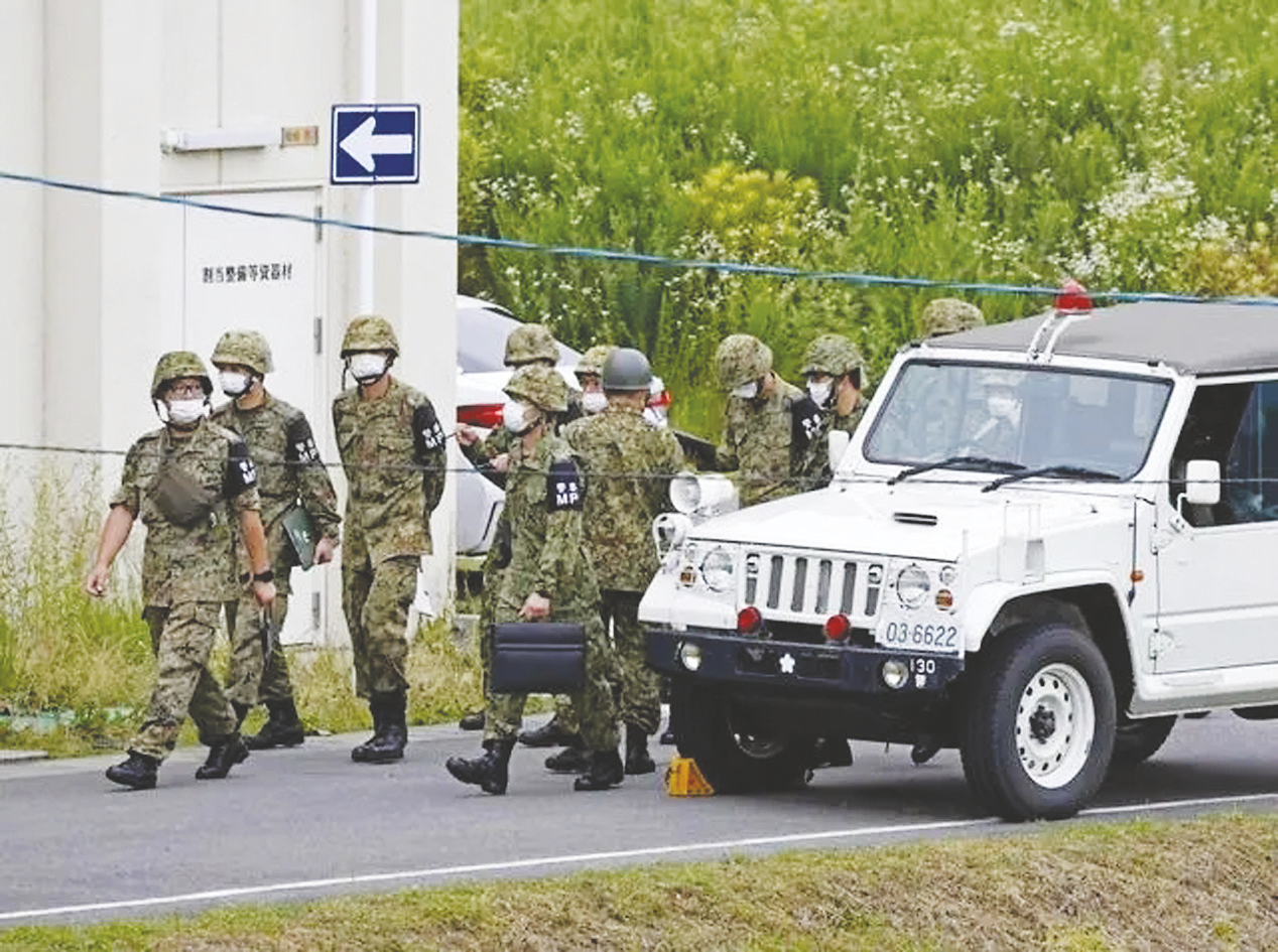   6月14日,日本自衛隊隊員聚集在發生槍擊事件的射擊訓練