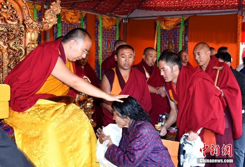 图为6月12日,班禅在西藏昌都强巴林寺为信众摸顶赐福.