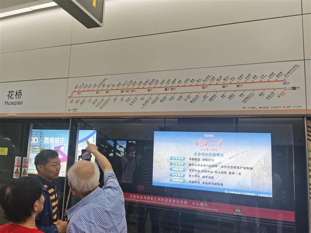 苏州轨交11号线花桥站站台上,乘客们正在交流线路布局. 任俊锰 摄