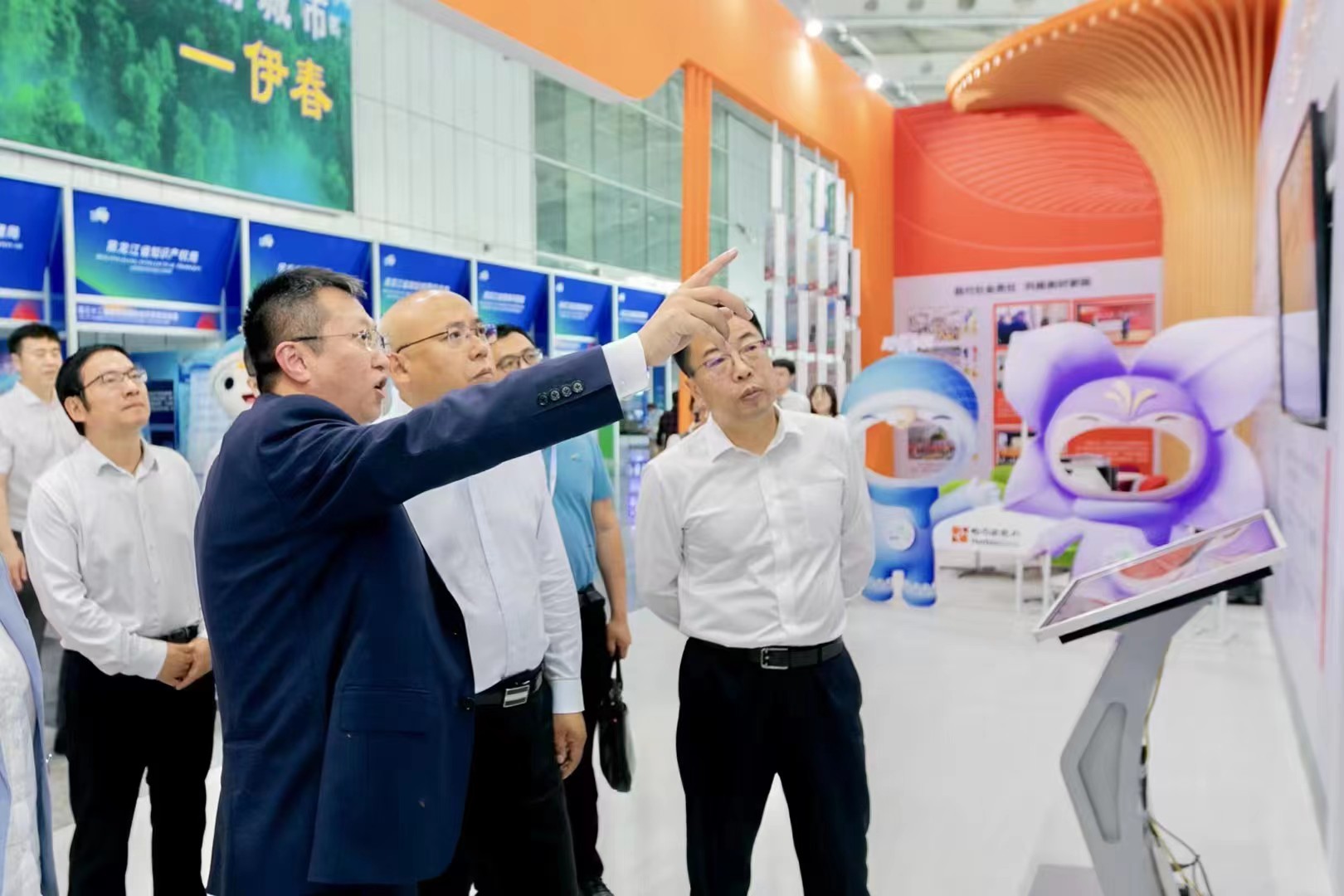 图为哈尔滨银行行长姚春和向嘉宾介绍展区内容