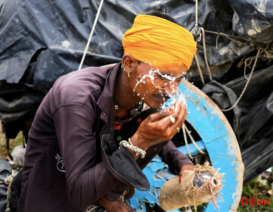 ↑在热浪席卷印度期间，该国通常会发生严重缺水的情况。图为一名印度人正在用水给自己降温