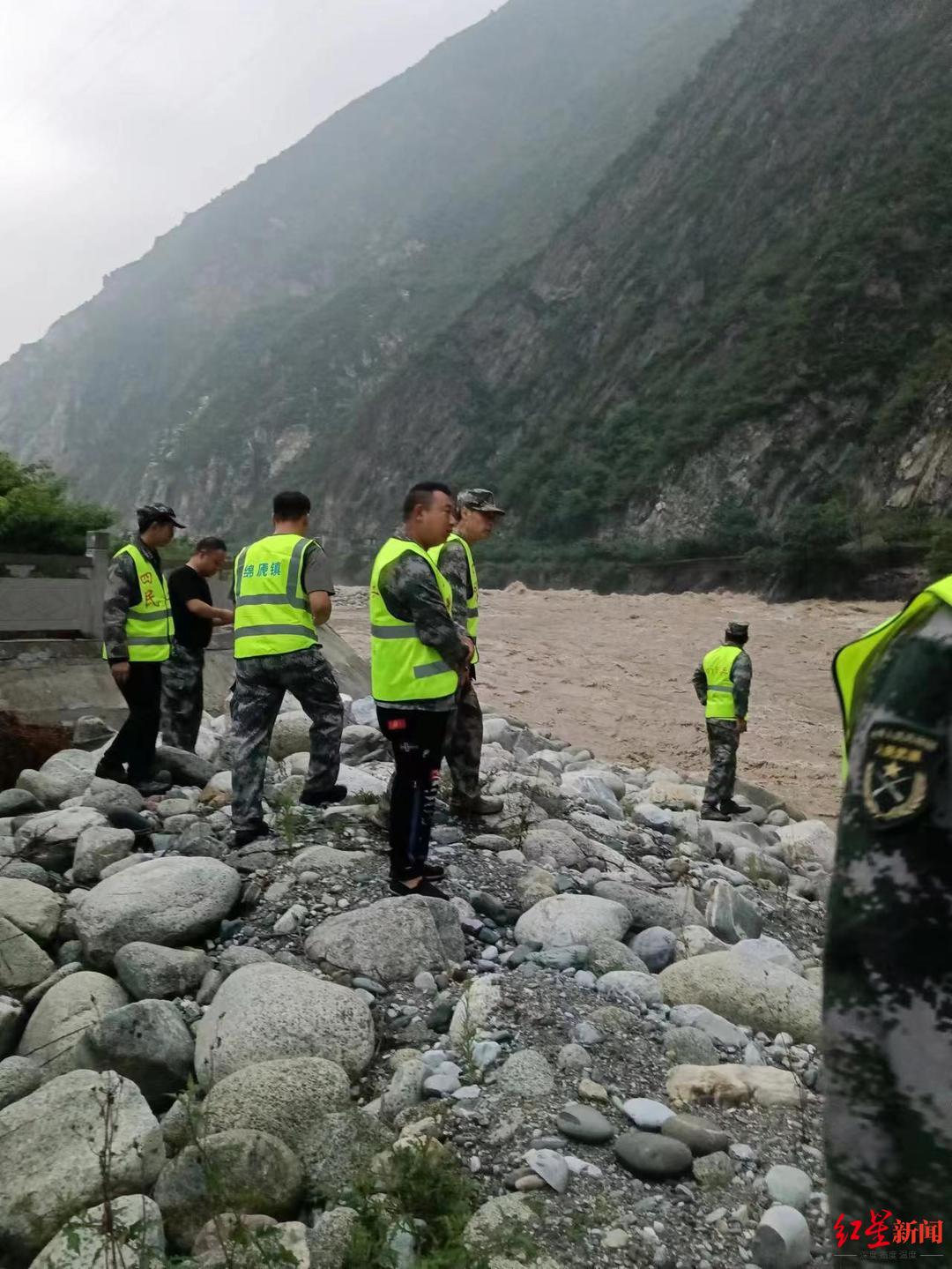 ↑救援人员沿着河道寻找失联人员