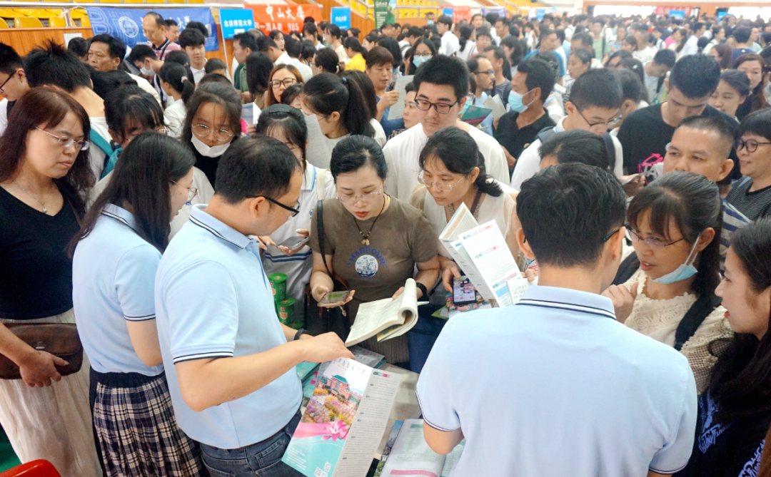 家长,考生在高校招生展位咨询报考事宜.