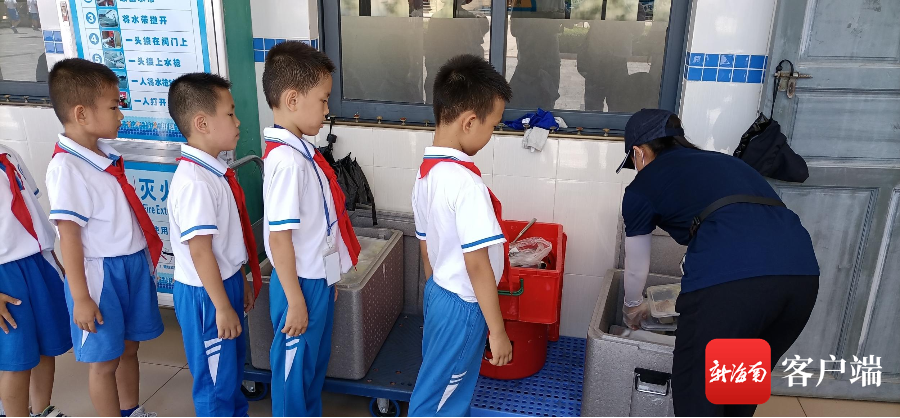 图为海景学校孩子们在排队取餐.记者 王康景 摄