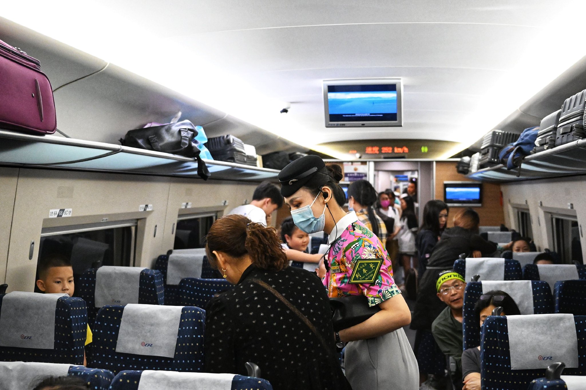 蓉港高铁首发列车上,列车长吴松霖正在服务乘客