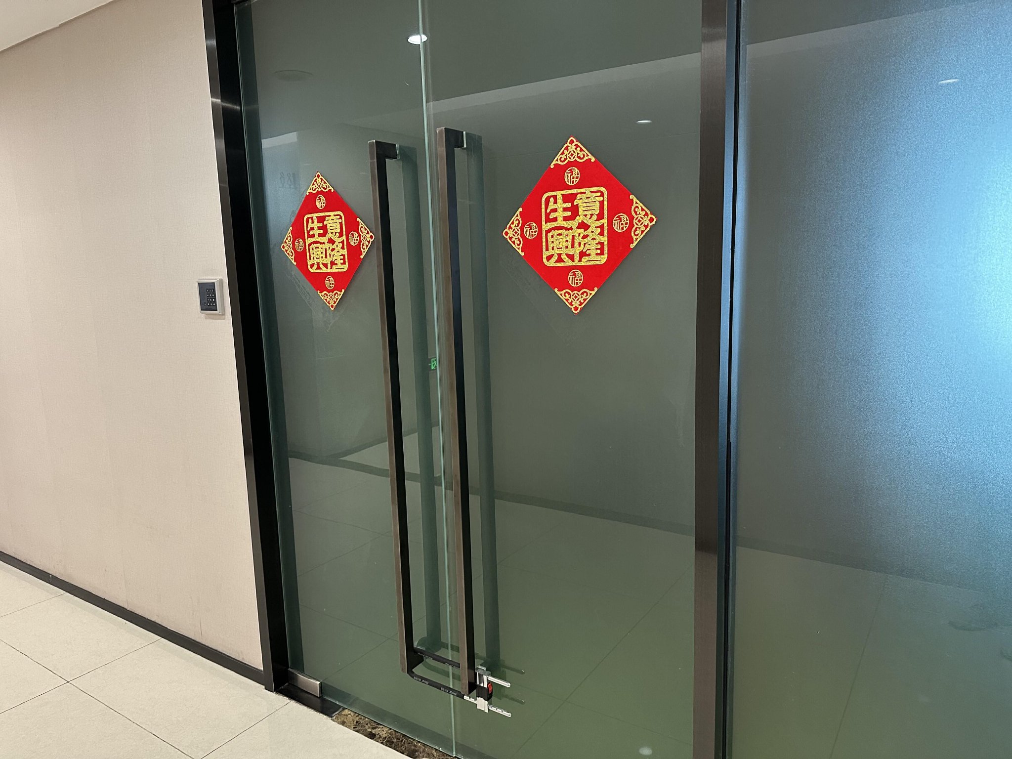 而在透过该公司办公室的另一扇门可以看到,其门口堆放的纸箱被白色