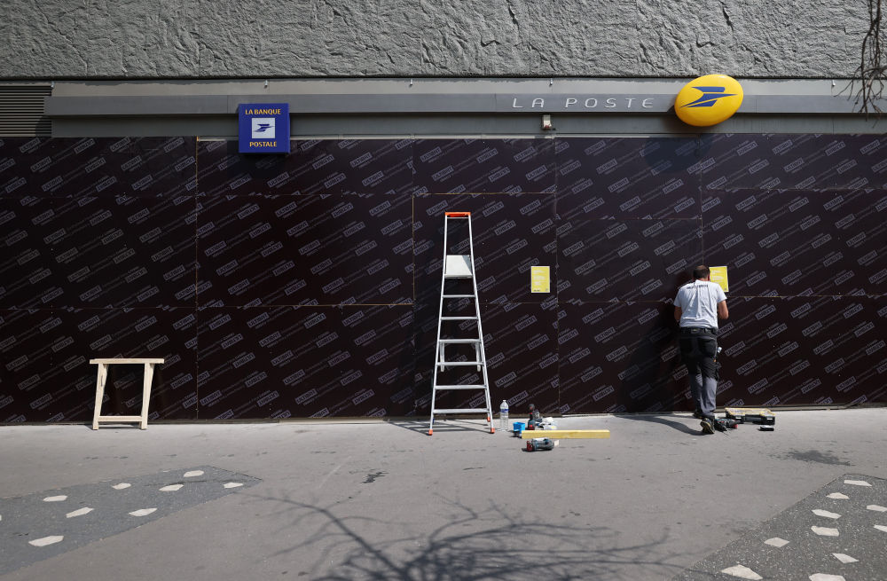 6月30日，在法国上塞纳省楠泰尔市，工作人员为一家邮局加装防护板（图片来源：新华社）