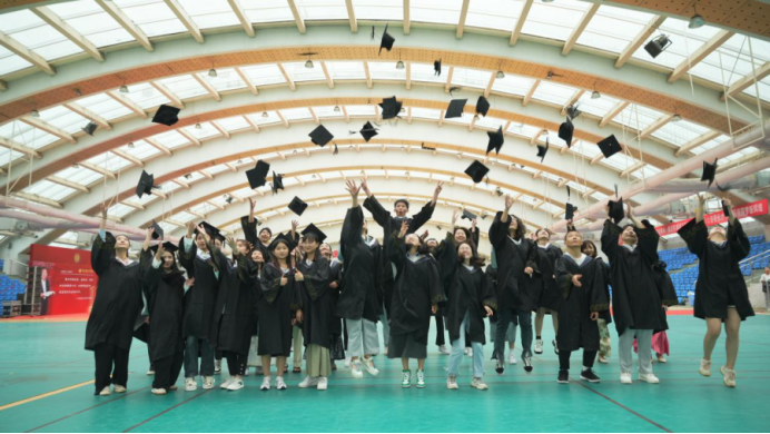 图：毕业生们高高抛起学士帽庆祝毕业
