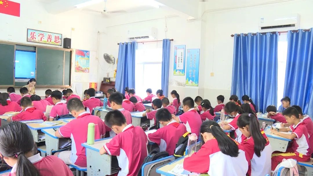 在东方市铁路小学,学生在凉爽的教室里认真听讲.