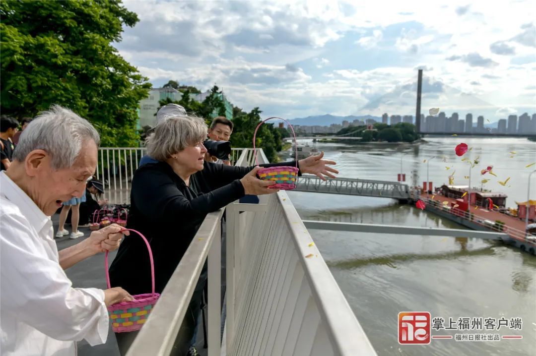 穆言灵在闽江畔抛撒花瓣.陈暖&nbsp;摄
