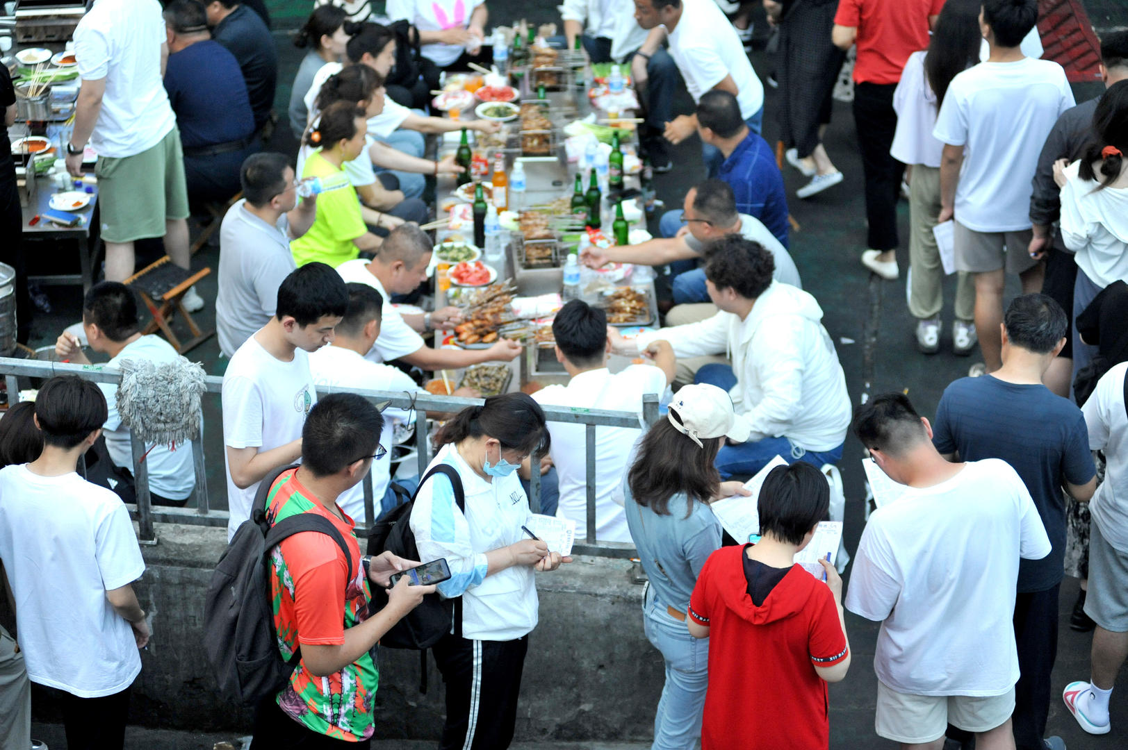 ↑2023年6月17日，山东淄博，食客边排队边点菜。图据视觉中国