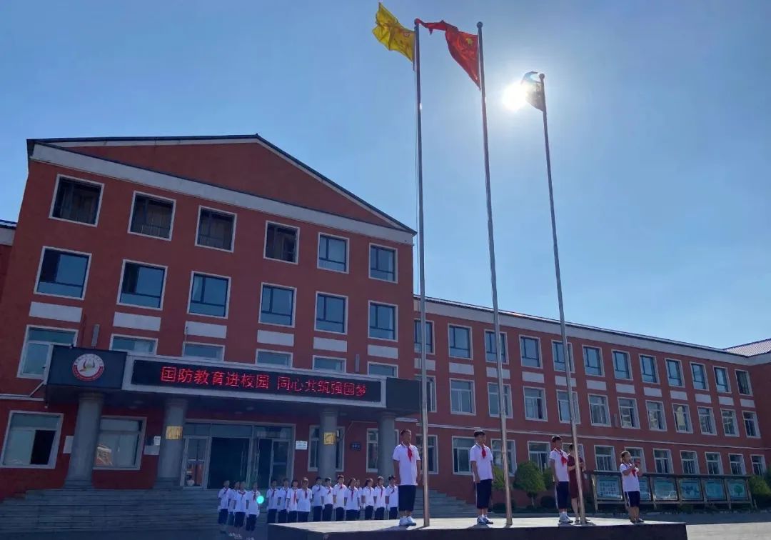 校服的学生身着 "迷彩"的官兵鲜艳的五星红旗冉冉升起在铁岭县腰堡九