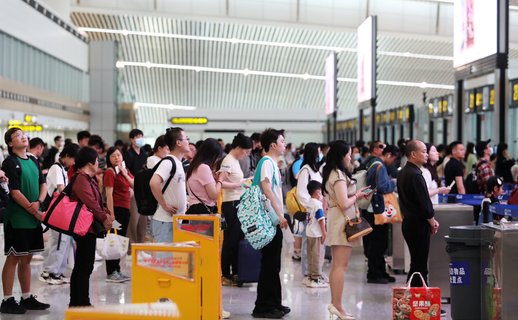 旅客正在排队过安检.江北机场新闻中心供图