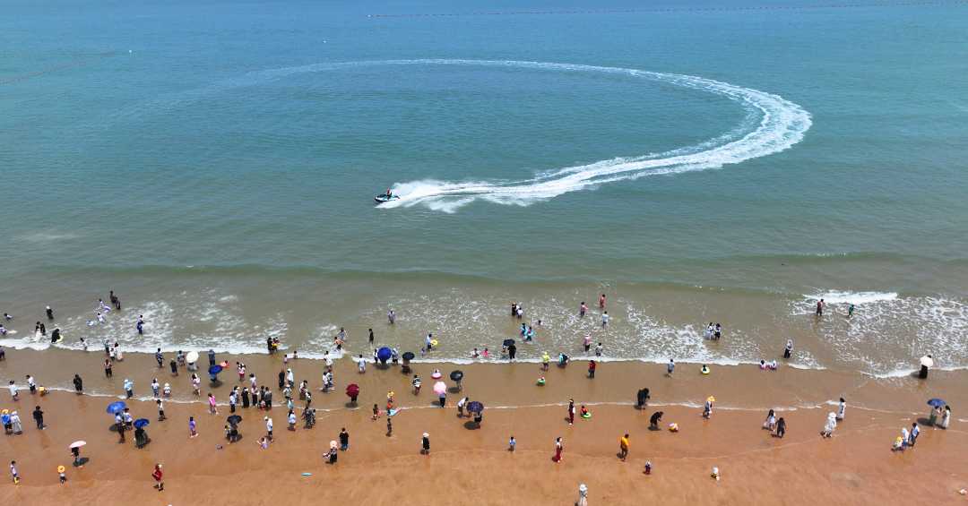 03,0.77%)市连岛海滨浴场,众多游客在戏水消暑.