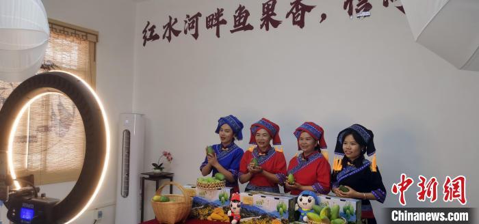 7月5日，覃爱荣(右二)和三个姐妹一起，正在忙着“新农活”——直播带货。　中新社记者 　蒋雪林 　摄