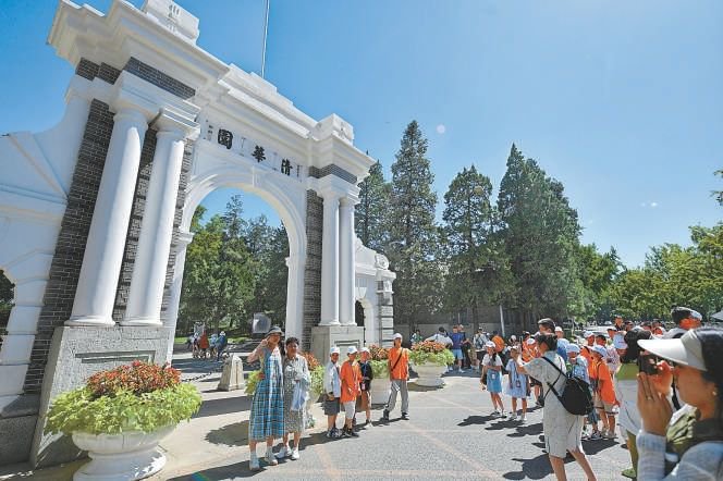 昨天上午,清华大学向社会公众恢复校园暑期参观,游客们在校园标志性