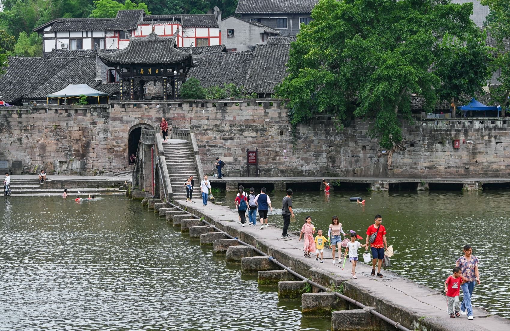 6月28日,荣昌区路孔古镇(现万灵镇),游客走在大荣桥上.