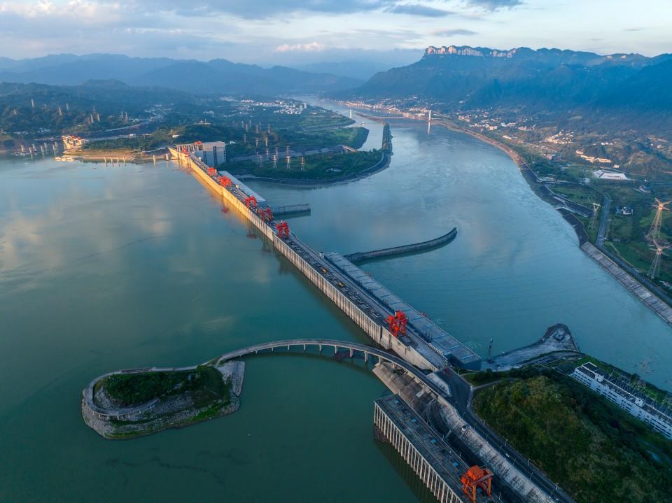 这是7月9日在湖北省宜昌市拍摄的夕阳映照下的三峡水利枢纽工程(无人