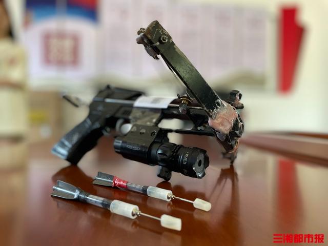 (嫌疑人使用的弓弩和飞镖.杨洁规 摄)