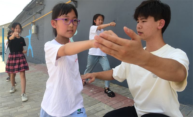 7月10日,在河北沧州,志愿者张翔宇为董林村学生传授武术.