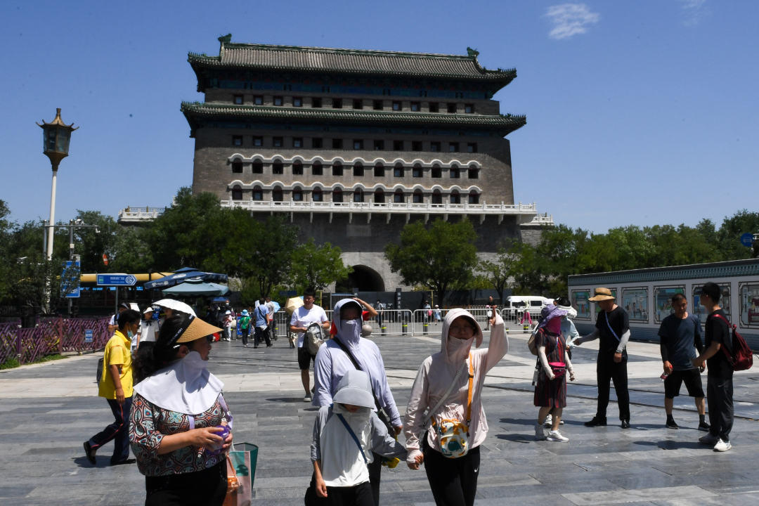 ▲7月6日，北京再次发布高温红色预警。图为游客走在北京市前门大街上。图据新华社